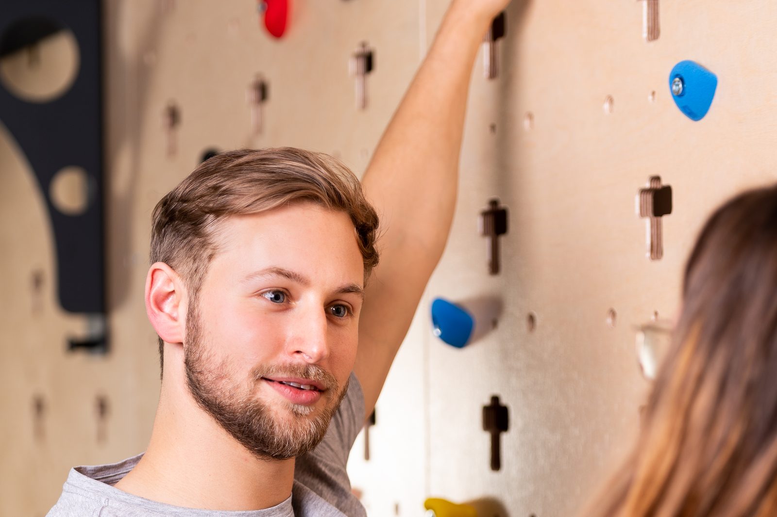 Cliënt aan de klimwand met therapeut