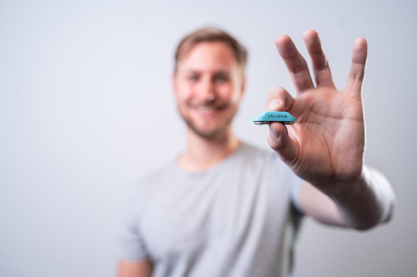 Model houdt een PicoBlue-sensor tussen twee vingers